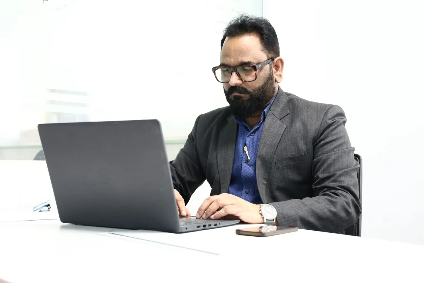 A consultant working at a desk with a laptop