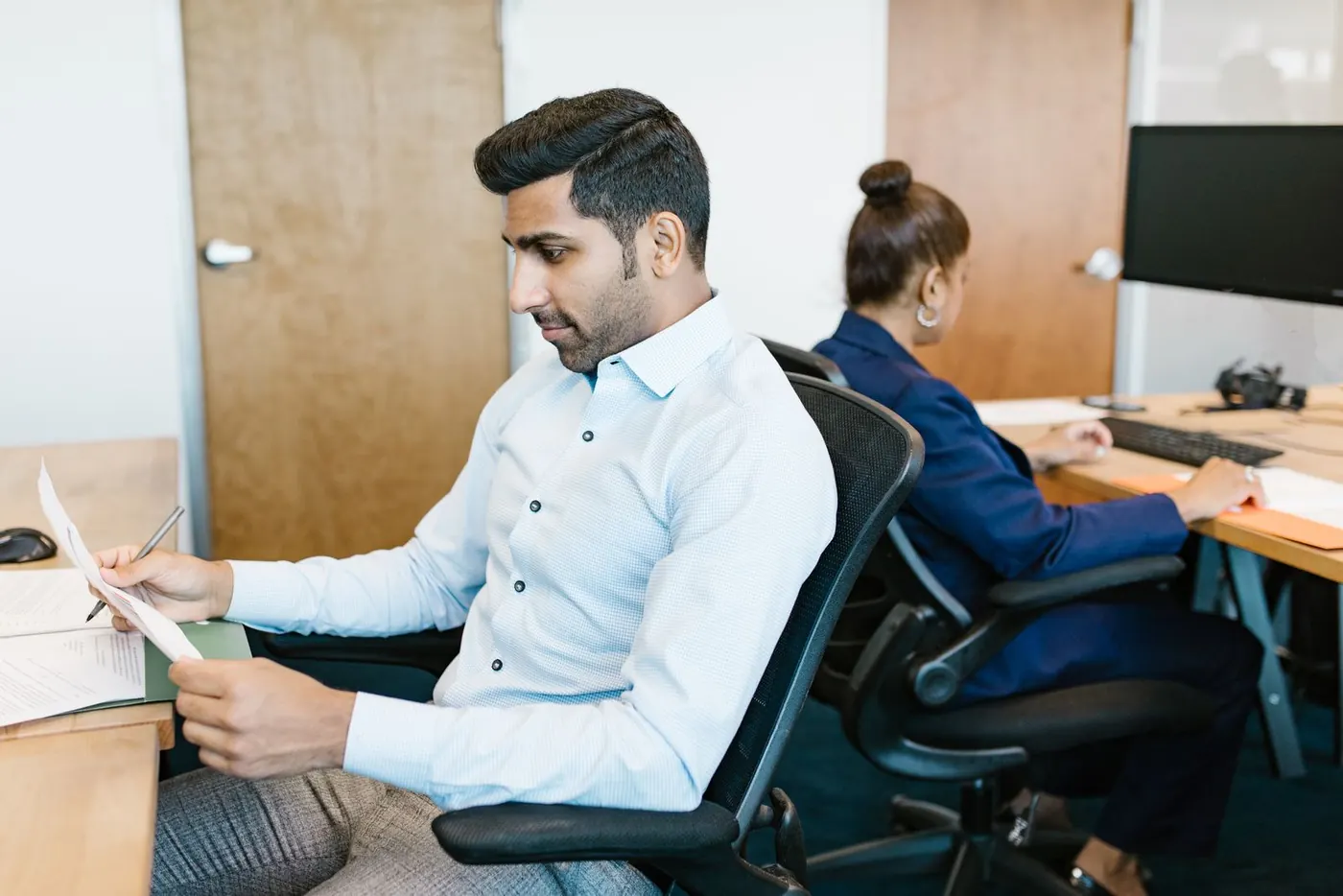 A business owner going through printed records at his desk