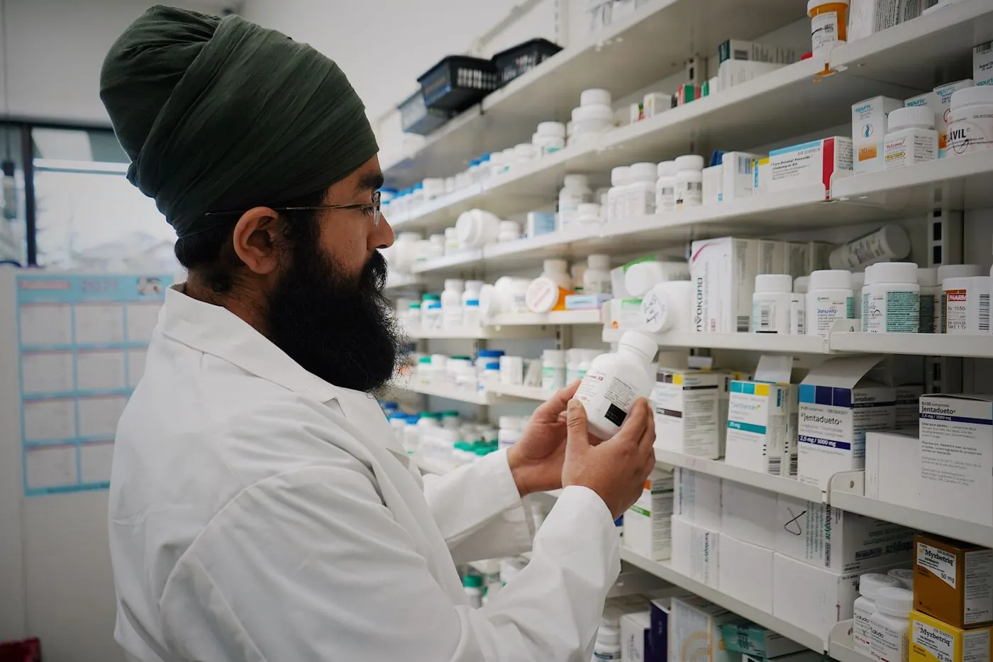 A pharmacist checking medicine stock on the shelves