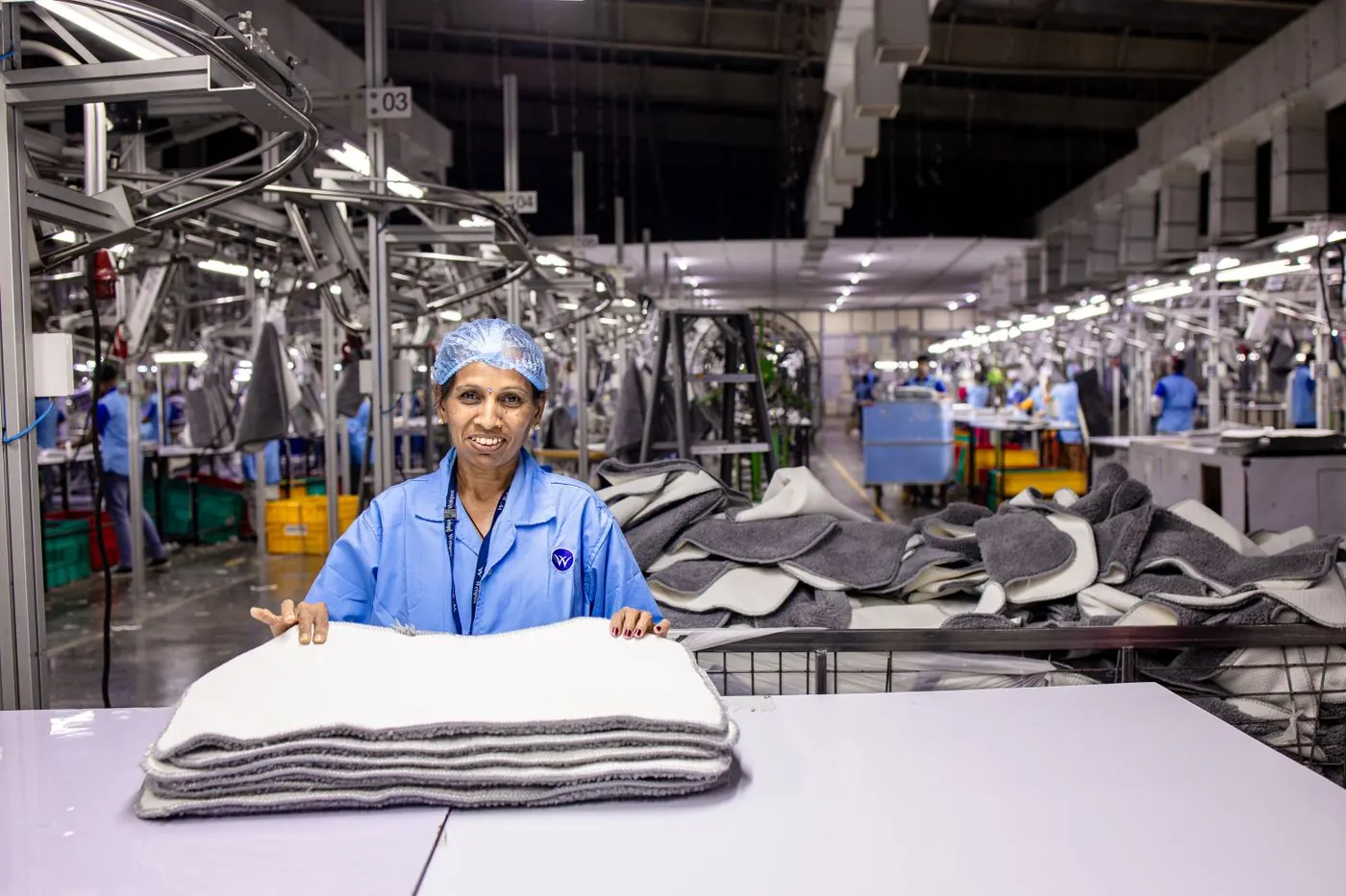 Workers at sewing machines on a small factory floor